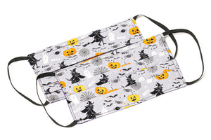 Handmade Halloween cloth face masks with witches and pumpkins on gray fabric
